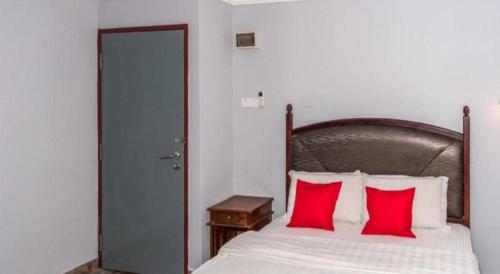 a bedroom with a bed with two red pillows at OYO 890 Hotel RK Cahaya in Labuan