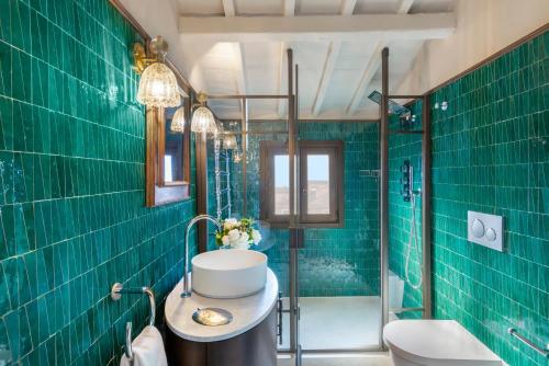 a bathroom with green tiled walls and a sink at The James Suite Hotel Firenze 1564 - Small Luxury Hotels of the World in Florence