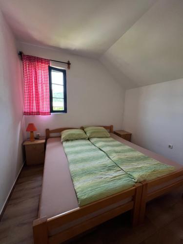 a bed in a room with a red window at Vila Zelenika Drina 