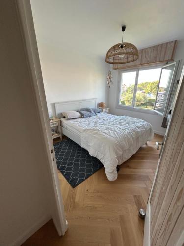 une chambre avec un lit et une grande fenêtre dans l'établissement Appartement 60m2 à 500m des plages, à Antibes