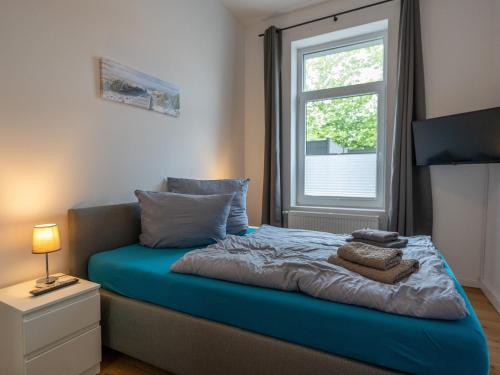 a bedroom with a blue bed with a window at Traum-Ferienwohnung Mozart ! in Wilhelmshaven