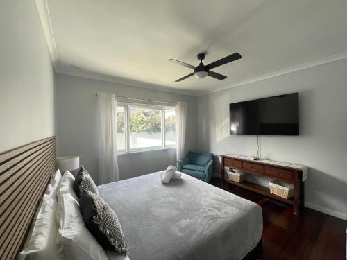 a bedroom with a bed and a flat screen tv at Dempster House in Esperance