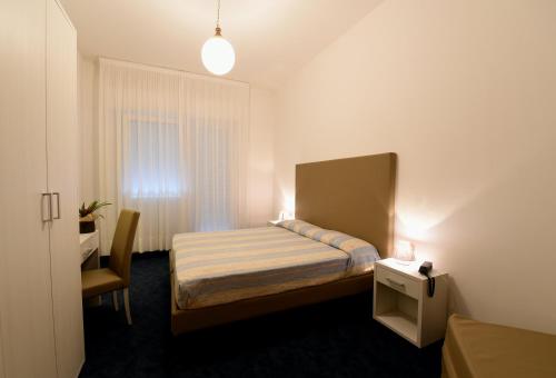 a small bedroom with a bed and a window at Hotel Savoia in Lido di Jesolo