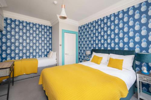 1 dormitorio con 2 camas y papel pintado azul y blanco en Dream Stays Bath - Kingsmead Street, en Bath