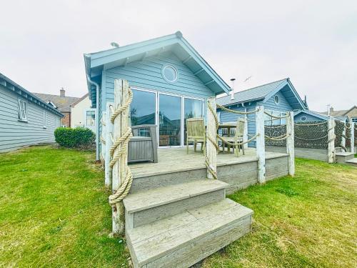 a blue house with a wooden staircase leading to a porch at JaBry Beach House Filey in Filey
