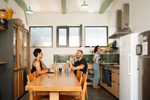 a group of people sitting around a table in a kitchen at YASI Hostel in Lyon
