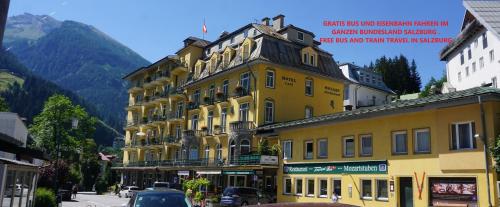 a yellow building on the side of a street at Kurhotel & Hotel Mozart in Bad Gastein