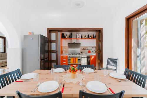 a dining room with a table with chairs and a refrigerator at L`Oasi del Mare by BarbarHouse in Torre rinalda
