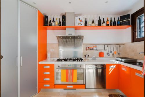 a kitchen with orange cabinets and a stove at L`Oasi del Mare by BarbarHouse in Torre rinalda
