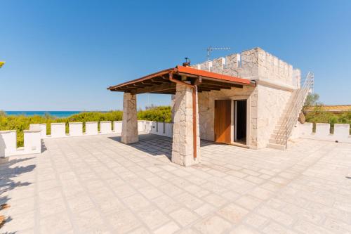 a small building with a roof on a patio at L`Oasi del Mare by BarbarHouse in Torre rinalda