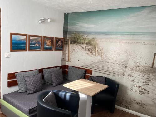 a restaurant with a table and a painting of the beach at Ferienwohnungen Alexandrinenstraße in Warnemünde in Warnemünde