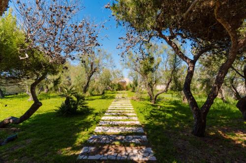 a stepping stone path in a park with trees at L`Oasi del Mare by BarbarHouse in Torre rinalda