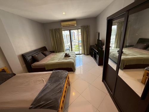 a hotel room with two beds and a mirror at Emerald hotel in Jomtien Beach