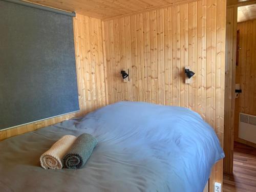 a room with a bed with two towels on it at L'Écorce & le Tanin - 2 cabanes cosy pour 4, pêche in Roye