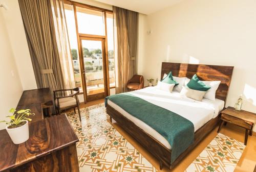 a hotel room with a bed and a large window at NAAD WELLNESS in Sonīpat
