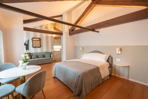 a bedroom with a bed and a table and chairs at Castello di Porcìa - Residence Agrituristico in Porcia