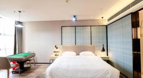 a bedroom with a bed and a pool table at Echarm Hotel Xiangyang Erqi in Xiangyang