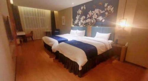 a bedroom with a large bed with a painting on the wall at Magnotel Shenyang Consulate Qingnian Street in Shenyang