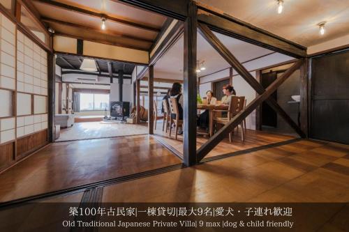 uma sala de estar com pessoas sentadas à mesa em 一棟貸切古民家,信州麹屋の宿,愛犬OK, 平日割,最大9名,Private villa em Okaya