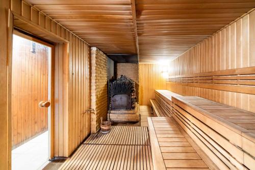 a sauna with wooden benches and a fireplace at Poilsio kompleksas Tolieja Vieta renginiams bei poilsiui ant ežero kranto in Kulionys
