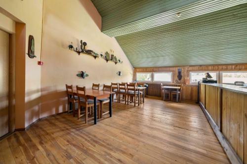 a dining room with a table and chairs at Poilsio kompleksas Tolieja Vieta renginiams bei poilsiui ant ežero kranto in Kulionys