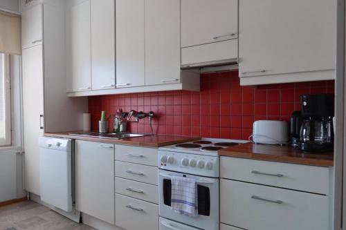 a kitchen with white cabinets and a stove top oven at Apartment Vanhatie, 3mh in Pyhäjoki