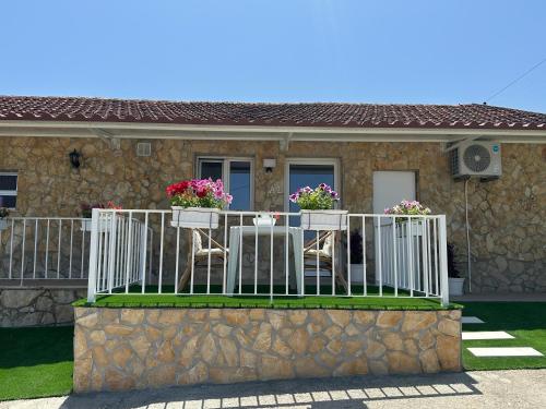 a house with a balcony with chairs and flowers on it at Refúgio da Serra in Porto de Mós