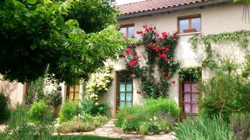 une maison avec des fleurs sur son côté dans l'établissement Paysannerie des Versanes - Chambres et gîte, à Tour-de-Faure