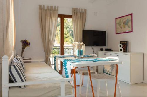 ein Wohnzimmer mit einem Tisch und einem TV in der Unterkunft Apartments Fig&Olive in Zaton