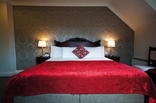 A bed or beds in a room at Killarney Riverside Hotel