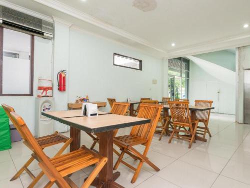 a dining room with wooden tables and chairs at The Studio Inn Nusa Dua in Ubud