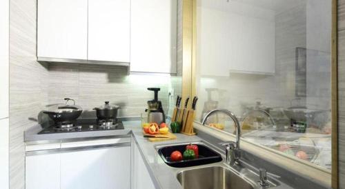 a kitchen with a sink and a counter top at Huafa Executive Apartment Hotel Zhuhai in Zhuhai