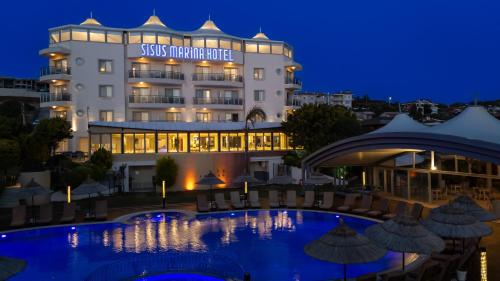 a hotel with a swimming pool at night at Sisus Marina Hotel in Çeşme