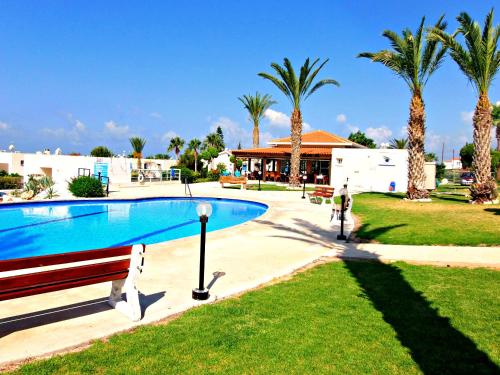 ein Swimmingpool in einem Garten mit Palmen in der Unterkunft Coral Bay Apartment - Prime Tourist Location in Coral Bay
