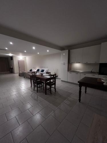 a living room with a table and chairs and a kitchen at Demetra Bed in Lizzanello