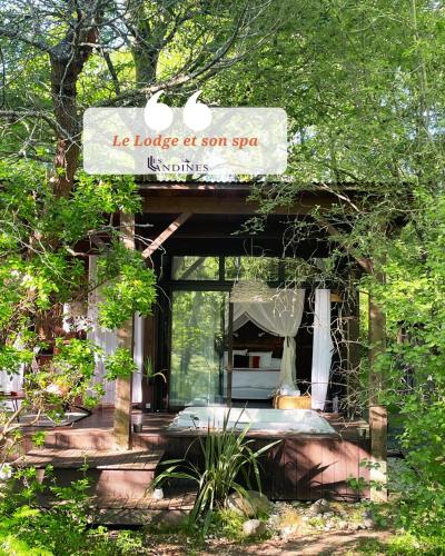 une petite maison dans les bois avec un panneau dessus dans l'établissement Les Landines, à Origne