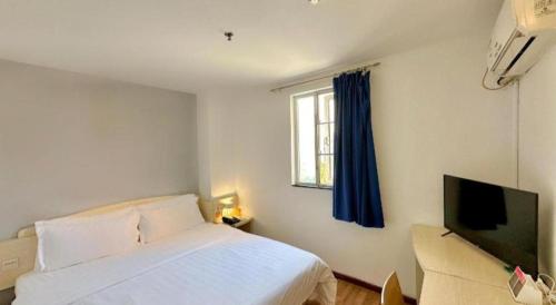 a bedroom with a bed and a flat screen tv at 7 Days Inn Guangzhou Zoo Huanghuagang Metro Station in Guangzhou