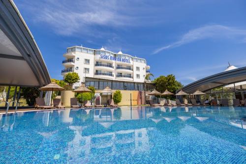 a large swimming pool in front of a hotel at Sisus Marina Hotel in Çeşme