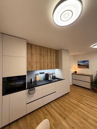a kitchen with white cabinets and a large ceiling at Visteria 10 in České Budějovice