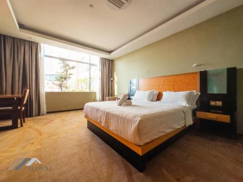 a hotel room with a large bed and a desk at Evernent Meritz in Miri