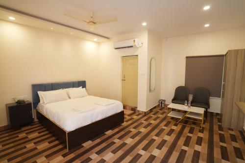 a bedroom with a bed and a table and chairs at Simbaa Resorts and Conventions 