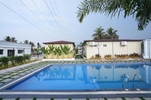 a swimming pool in front of a house at Simbaa Resorts and Conventions 