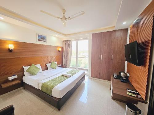 a bedroom with a large bed and a television at The Grace in Gurgaon