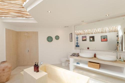 a white bathroom with two sinks and a mirror at Villa Cocodrilos 1 in Seminyak