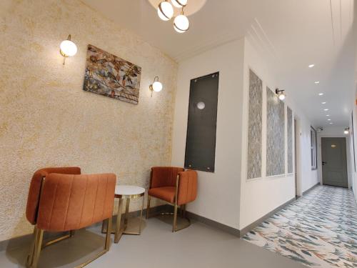 a room with two chairs and a table and a wall at HOTEL Elegance 5 min walk from Golden Temple in Amritsar