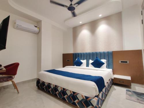 a bedroom with a large bed with blue pillows at HOTEL Elegance 5 min walk from Golden Temple in Amritsar