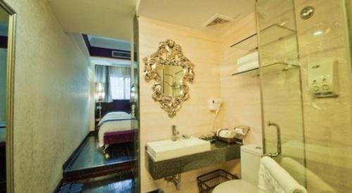 une salle de bain avec un lavabo et un miroir au mur dans l'établissement Guilin Sapphire hotel, à Guilin
