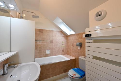 ein Badezimmer mit Badewanne, Waschbecken und Toilette in der Unterkunft Le Cottage du Tamaris - maison proche de la plage in Le Pouliguen