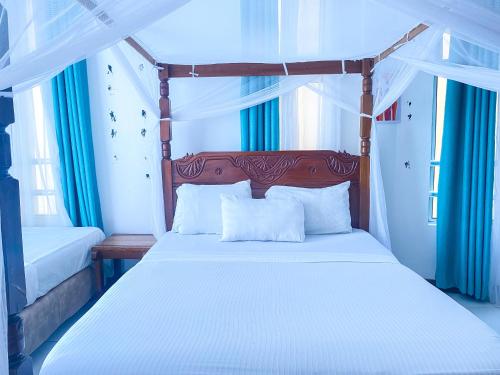 モンバサにあるCoastal nook 2 bedroom beach flat , Lidoの木製のヘッドボードが付いた白いベッドのある寝室