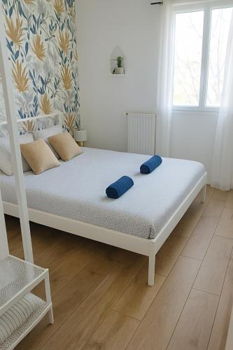 une chambre avec un lit avec des oreillers bleus dessus dans l'établissement Disneyland Paris 70m² face Parc, place Ariane, à Serris